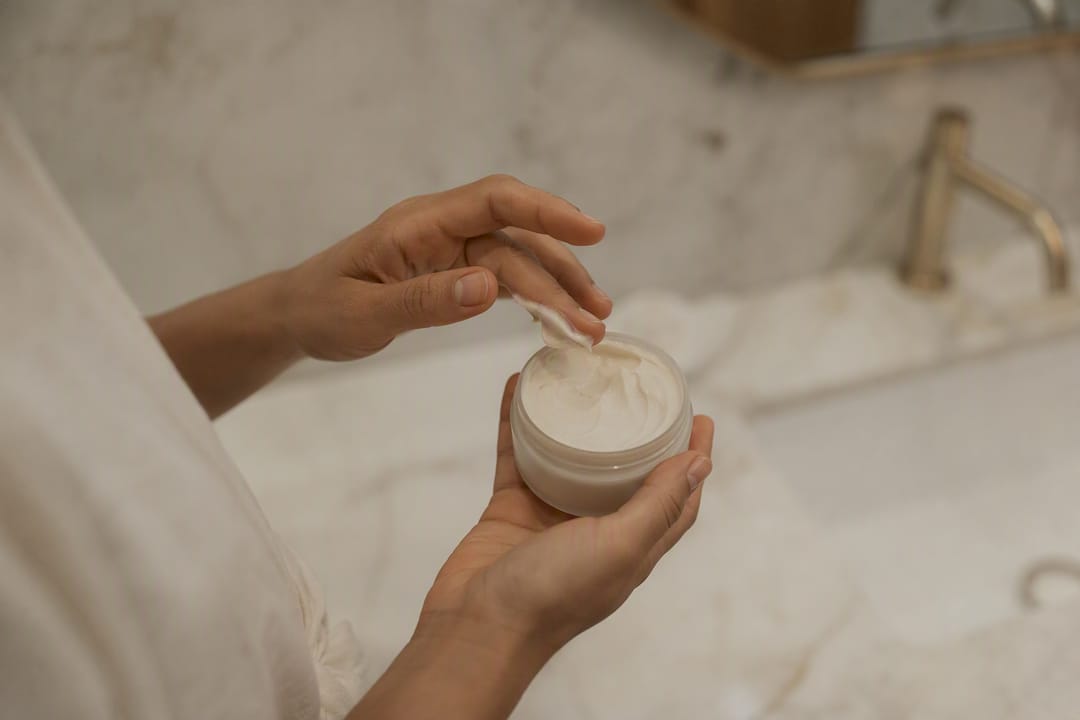 Hånd, der tager stylingcreme op