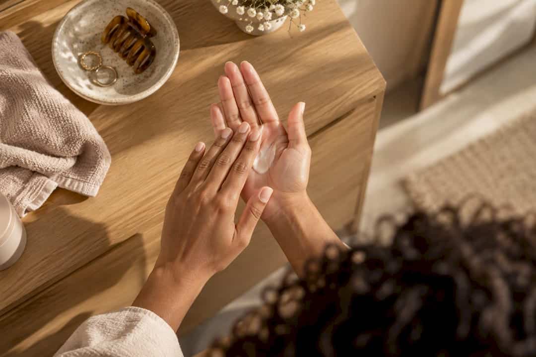 Hænder doserer stylingcreme til krøller